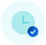 Light blue clock icon with simple hands set at 12 o’clock, overlaid by a smaller blue circle featuring a white check mark in the lower right corner, all on a pale circular background.