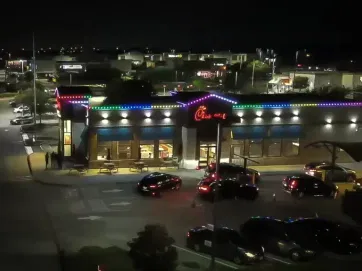 A building with cars parked in front of it at night.