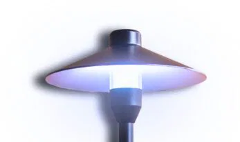A modern outdoor lamp post with a wide, flat, circular shade and a cylindrical light in the center, glowing with a soft white light against a white background.