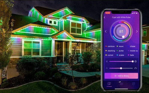 A two-story house decorated with colorful LED lights along the roofline at night. In the foreground, a smartphone displays an app for controlling the lights’ colors and effects.